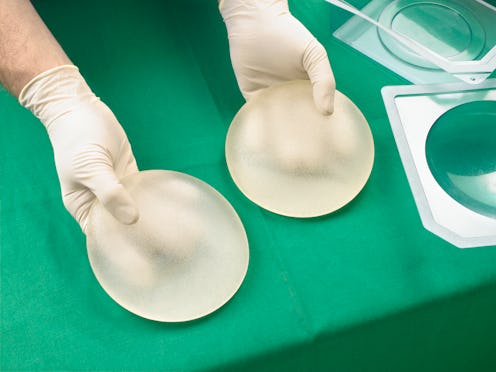 breast augmentation surgeon holding implants
