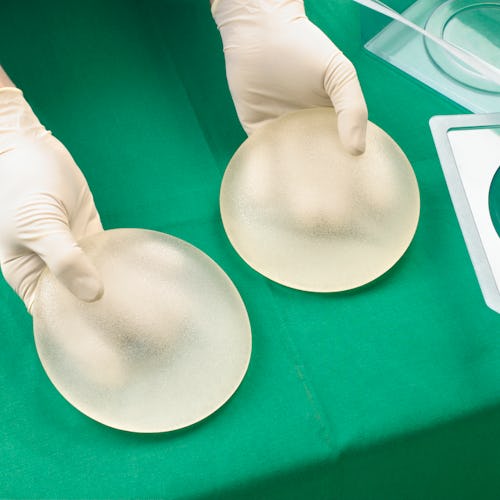breast augmentation surgeon holding implants