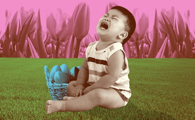 A small toddler boy sitting on the grass and crying