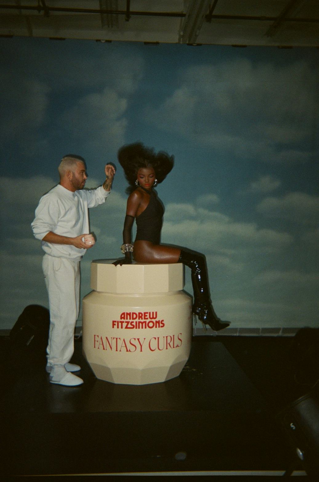 Andrew Fitzsimons styling a model&rsquo;s hair for his Fantasy Curls hair care products.