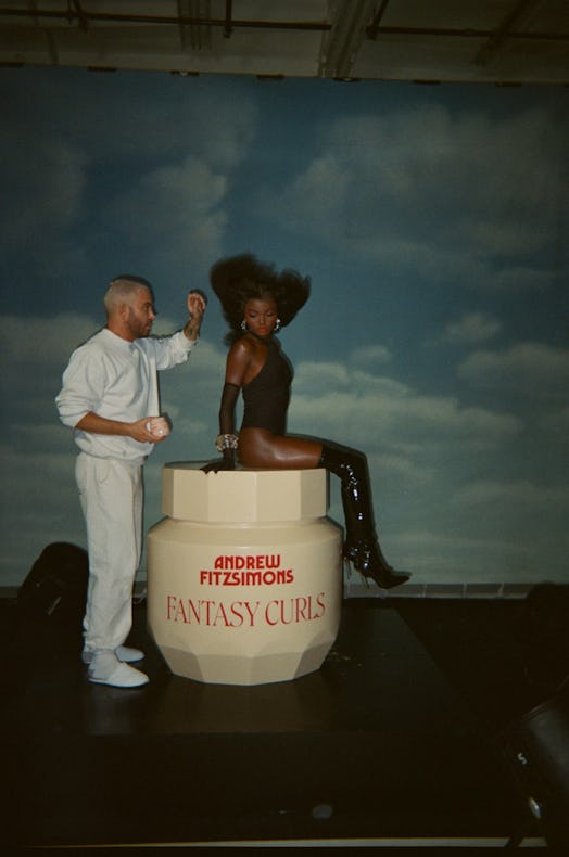 Andrew Fitzsimons styling a model’s hair for his Fantasy Curls hair care products.