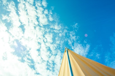A pole holding a tent with a blue sky in the background