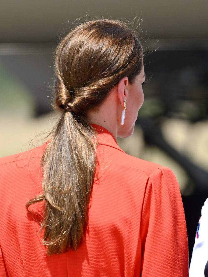 Kate Middleton wears a double twisted low ponytail at Philip S. W Goldson International Airport.