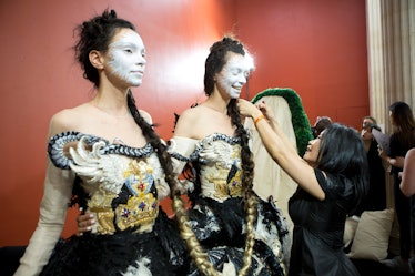 Designer Guo Pei adjusts a model's look backstage.