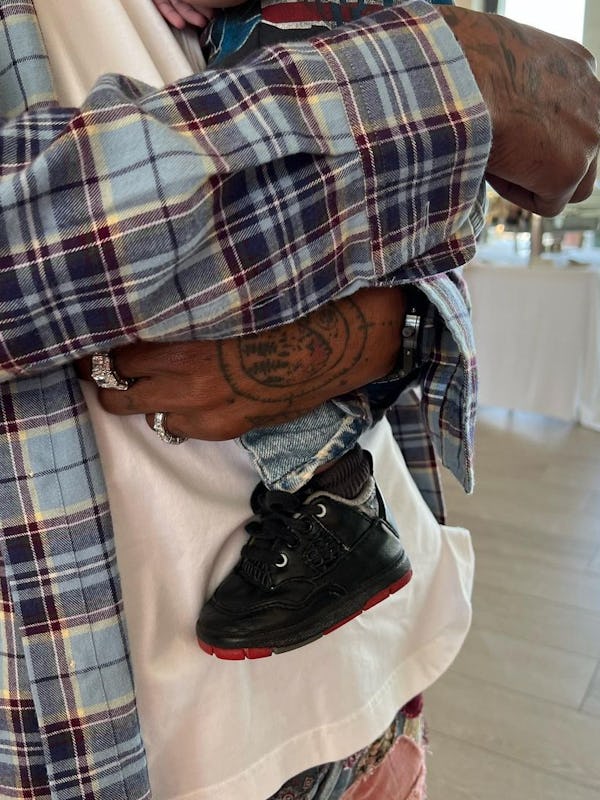 Travis Scott holding his second baby he had with Kylie Jenner.