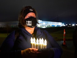 Marla Chassels holds battery-powered candles, representing each one of the Amazon employees killed d...