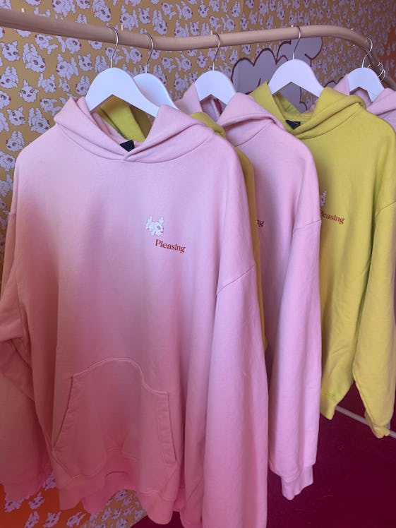 The Pleasing sweatshirt with the cloud fish logo has pink and yellow options on display.