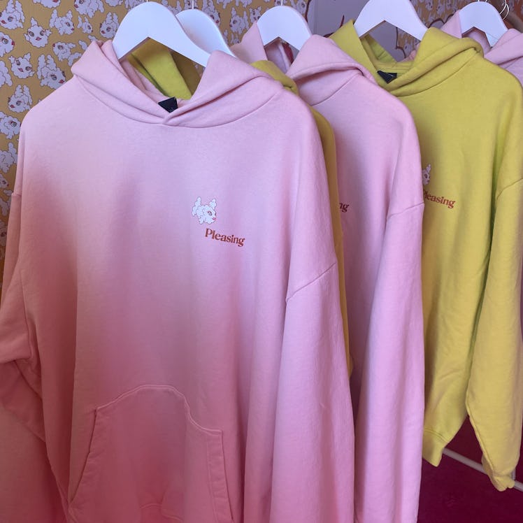 The Pleasing sweatshirt with the cloud fish logo has pink and yellow options on display.