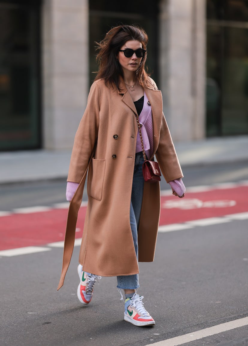 Ira Meindl in colorblock sneakers and a camel coat