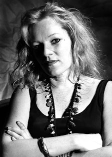 Cookie Mueller portrait, crossing her arms looking directly into camera