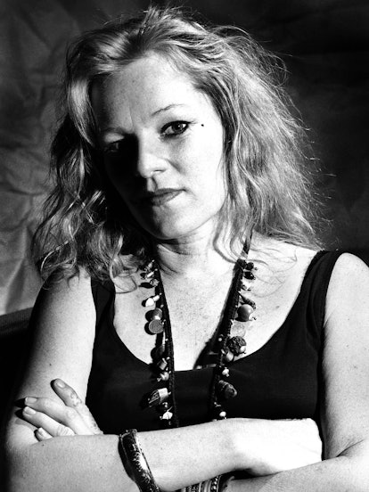 Cookie Mueller portrait, crossing her arms looking directly into camera