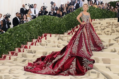 Blake Lively wearing a large red gown on the Met Gala red carpet