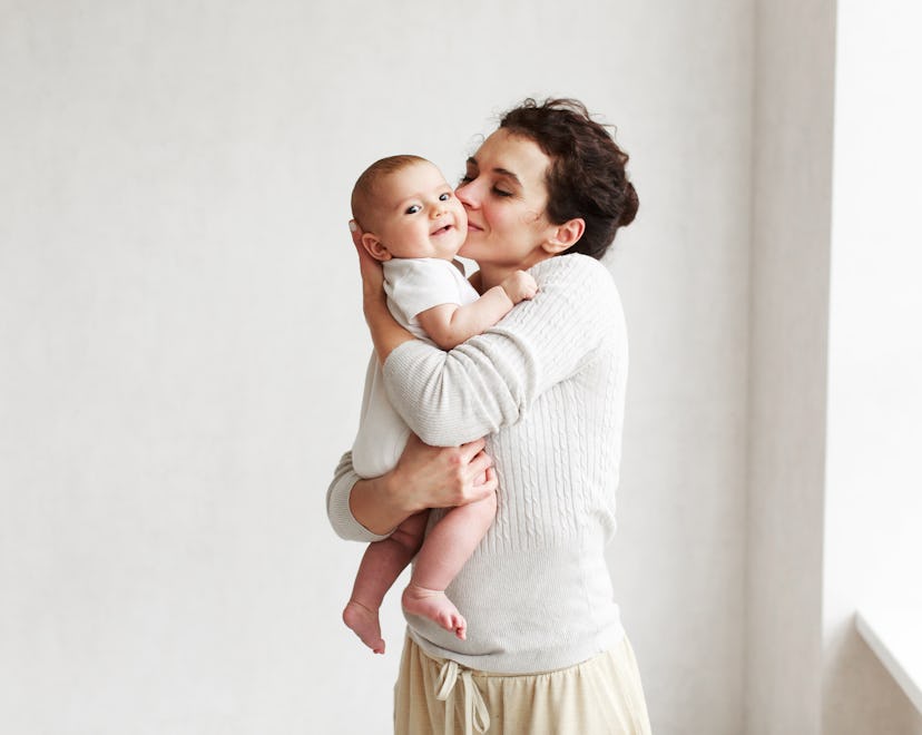 woman holding baby wearing onesie in her arms