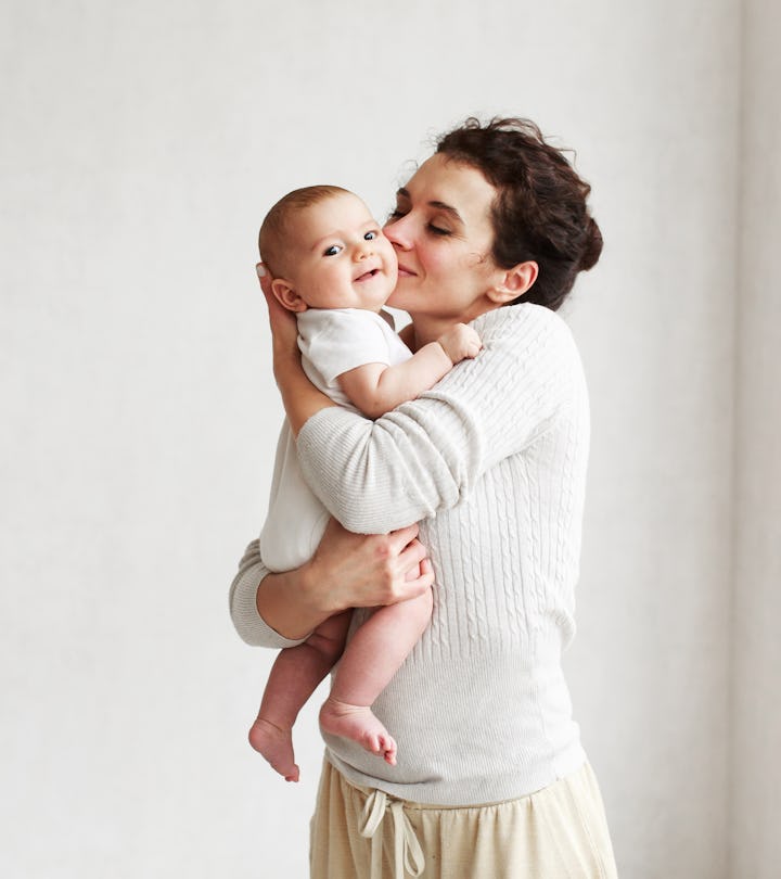 woman holding baby wearing onesie in her arms