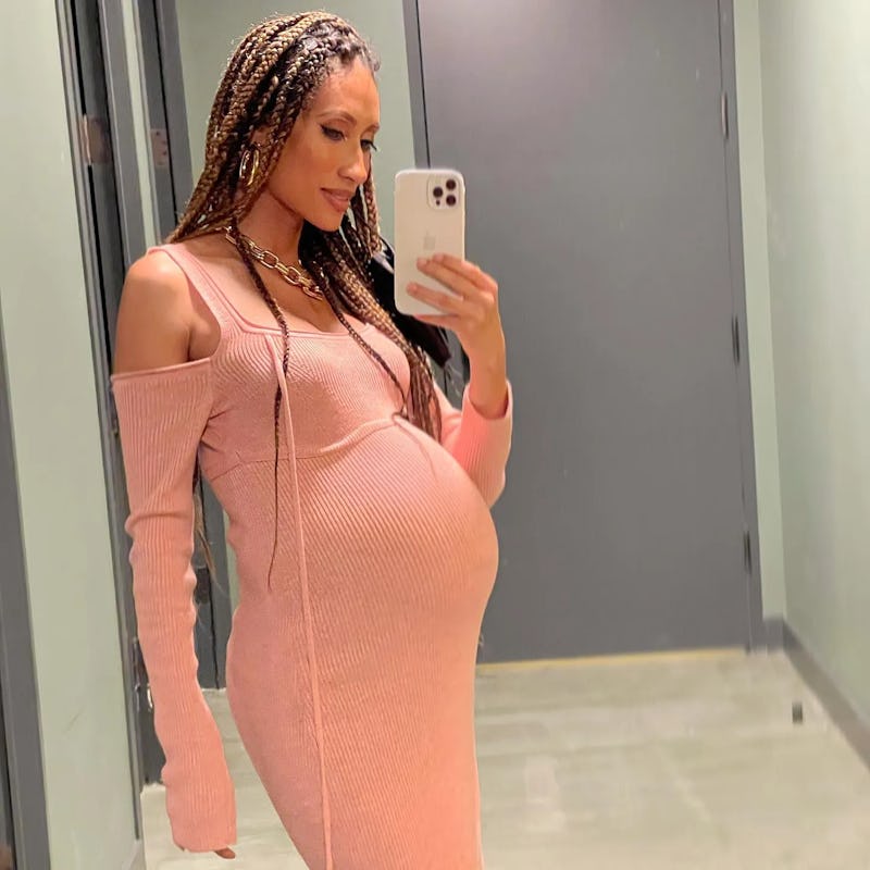 Elaine Welteroth wearing a pink ribbed dress while nine months pregnant