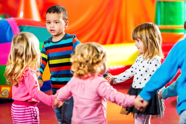 Toddlers Holding Hands And Standing In A Circle In The Kindergarten