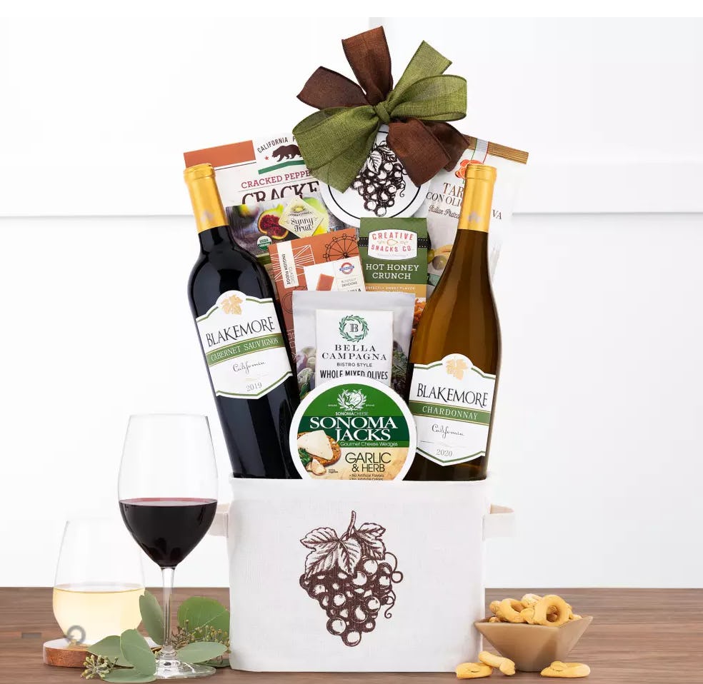 Red and white wine basket with cheese, olives, and crackers