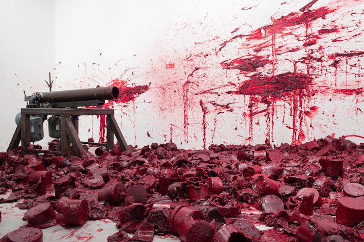 a cannon with red wax splattered all over the walls and ceiling around it