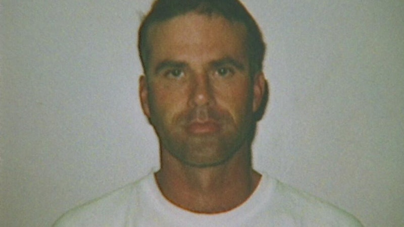 A photo of Cary Stayner as an adult. He wears a white t-shirt and stands in front of a white backgro...