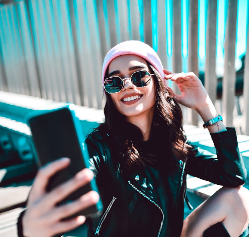 Young woman taking a selfie because her zodiac sign loves being the center of attention.