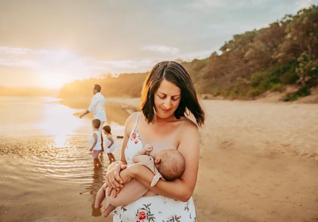 breastfeeding photoshoot ideas of mom on the beach with family