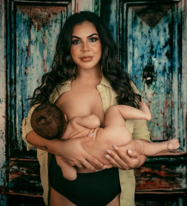 breastfeeding photoshoot ideas of mom holding baby looking at camera