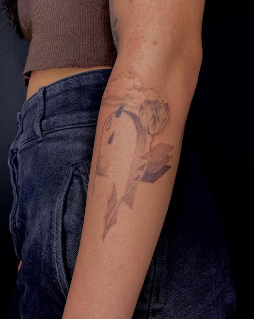 A woman's arm with a portal-like tattoo