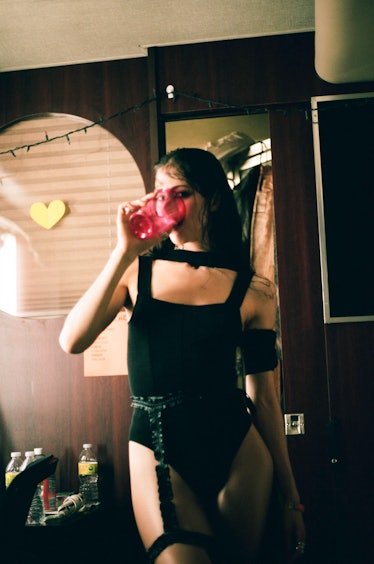 Caroline Polachek drinking a cup of water