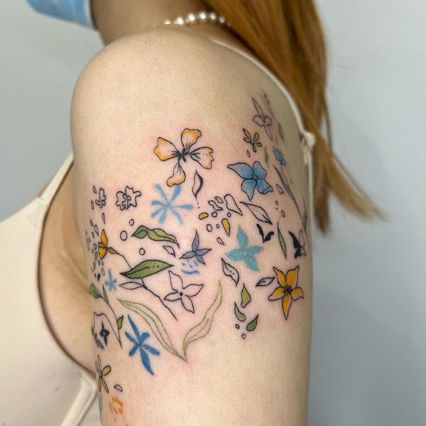 Woman's upper arm with a bunch of flowers tattooed on it