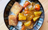 Japanese curry with potatoes, onions, carrots, as well as tofu katsu on a bed of white rice.
