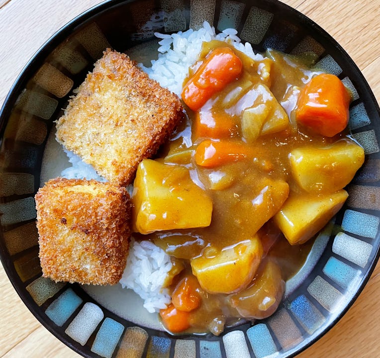 Japanese curry with potatoes, onions, carrots, as well as tofu katsu on a bed of white rice.