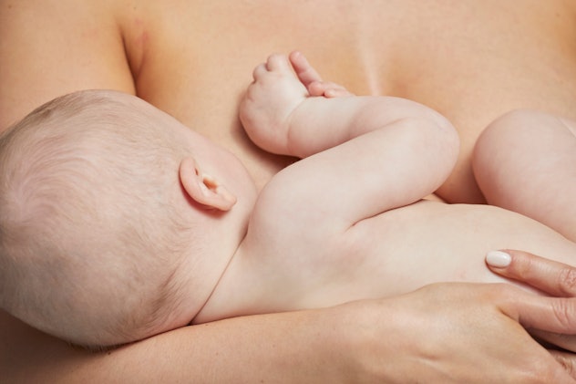Breastfeeding photoshoot ideas including this closeup of a light-skinned mother and nursing newborn