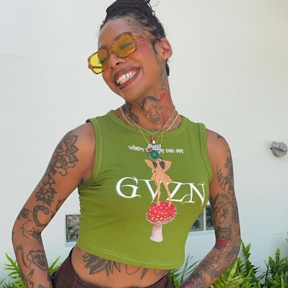 Woman wearing a green tank top and sunglasses smiling 