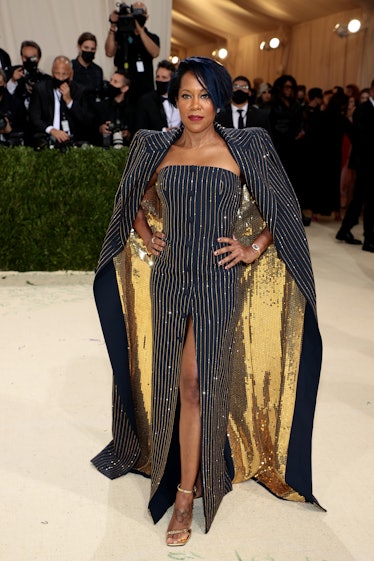 Regina king on met gala carpet wearing black and gold dress by michael kors