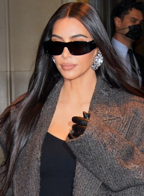 Kim Kardashian wears diamond candelier earrings with a gray jacket 