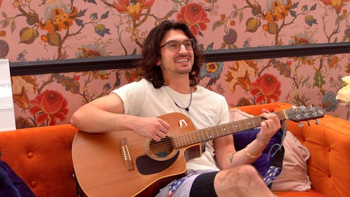 a screengrab of John Franklin as Carol in The Circle Season 4, sitting on an orange couch in front o...