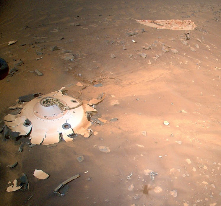 A soft-looking dusty surface. A broken white structure is seen at the bottom left corner of the imag...