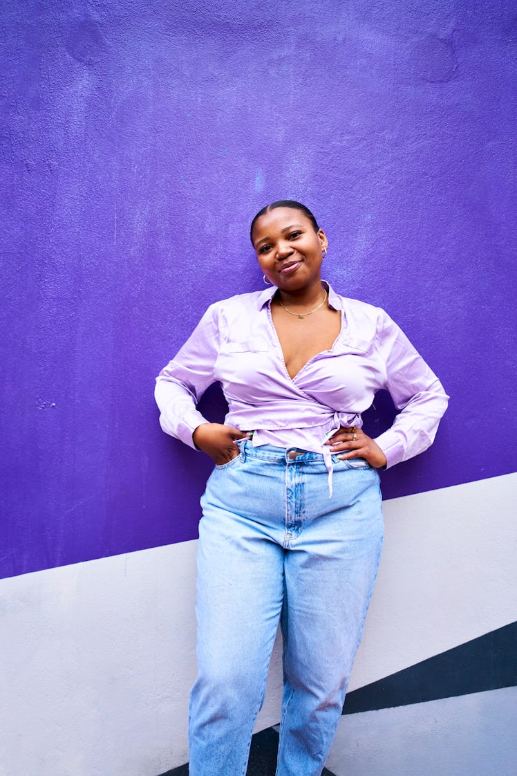 Young woman smiling against a purple background on the best day in May 2022 for every zodiac sign.