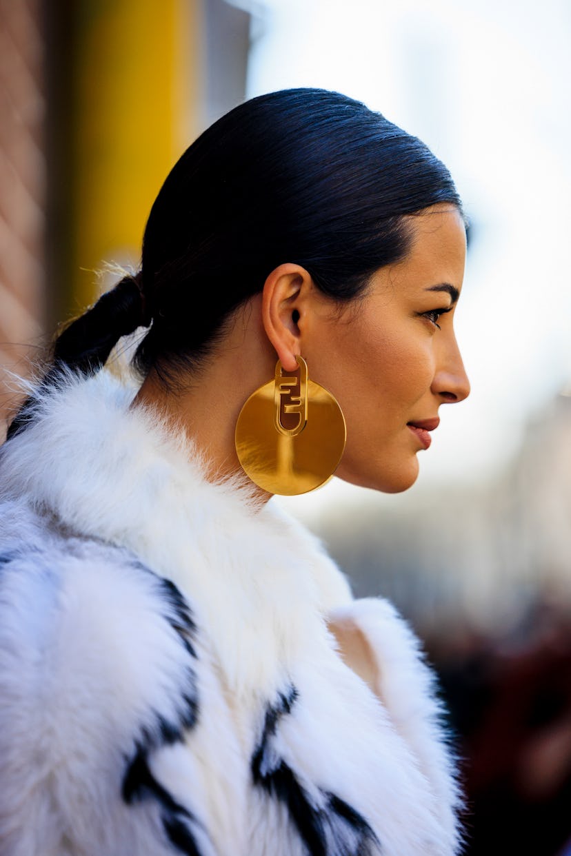 Street style star wearing gold earrings