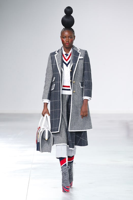 A model wearing a tweed suit with a white red and blue vest at Thom Browne's fall 2022 NYC show