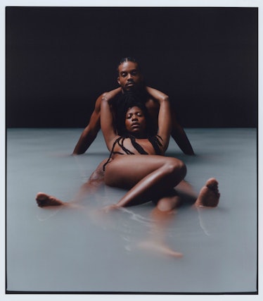 Photograph by Campbell Addy of two people lying in a pool with white water in it
