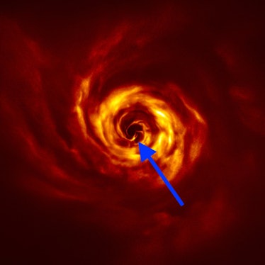 blue arrow pointing to a spot in a firey swirl where a planet likely resides