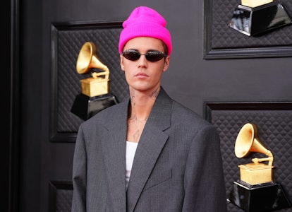 Justin Bieber wearing a fuchsia beanie on the Grammys 2022 red carpet