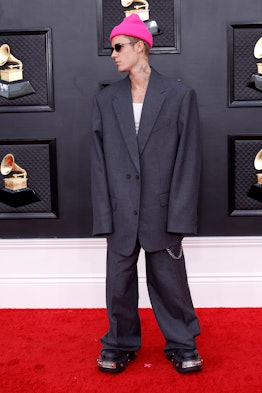 Justin Bieber wearing a fuchsia beanie on the Grammys 2022 red carpet