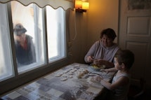 Baking with Grandmother, while Grandfather looks in the window, Ukraine.