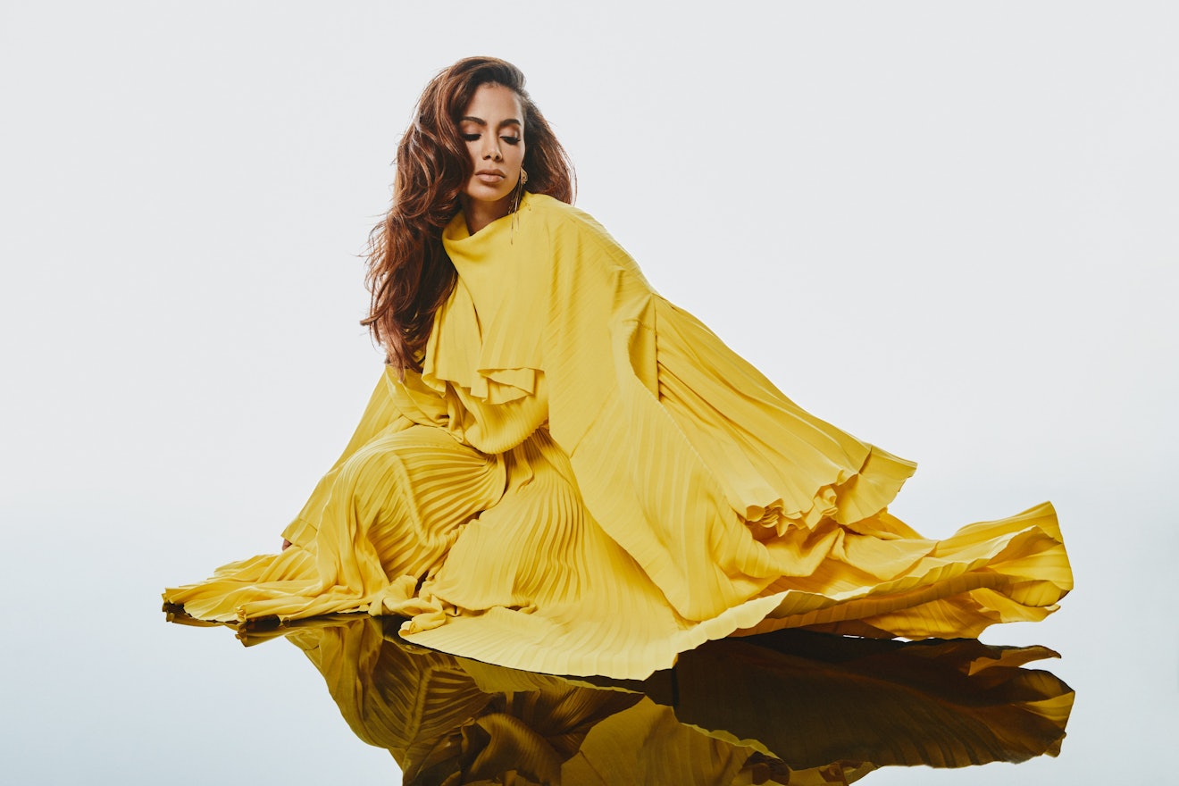 Anitta, the Brazillian pop star posing in a yellow all-coverage Balenciaga dress and L’Enchanteur ea...