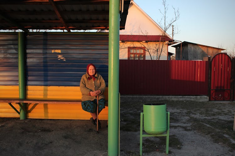 Elderly woman at a bus stop, Ukraine.