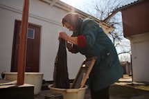 A woman washes clothes outside, Ukraine.