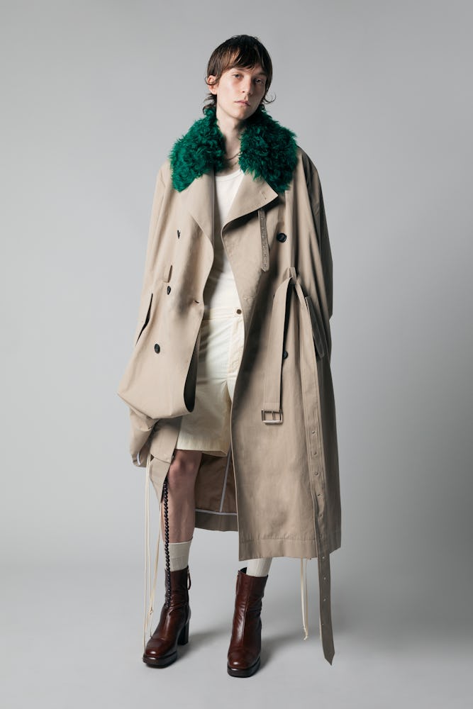 a model in a fur collared trench coat