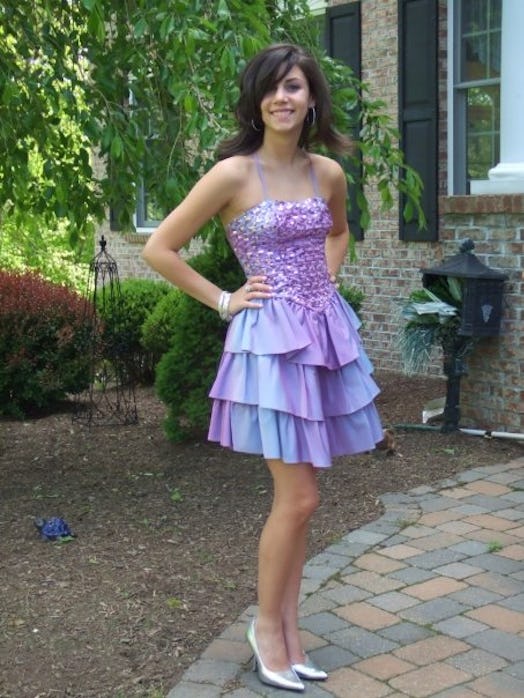 A woman posing in a short purple dress with a sequined bodice and a ruffled skirt. 